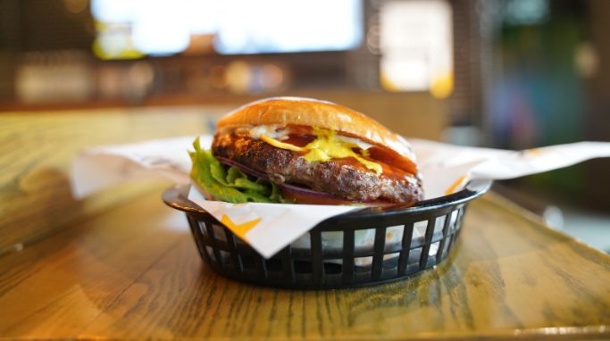 Burger menu med en saftig burger, sprøde pommes frites og iskold sodavand fra Carl's Jr i Randers 